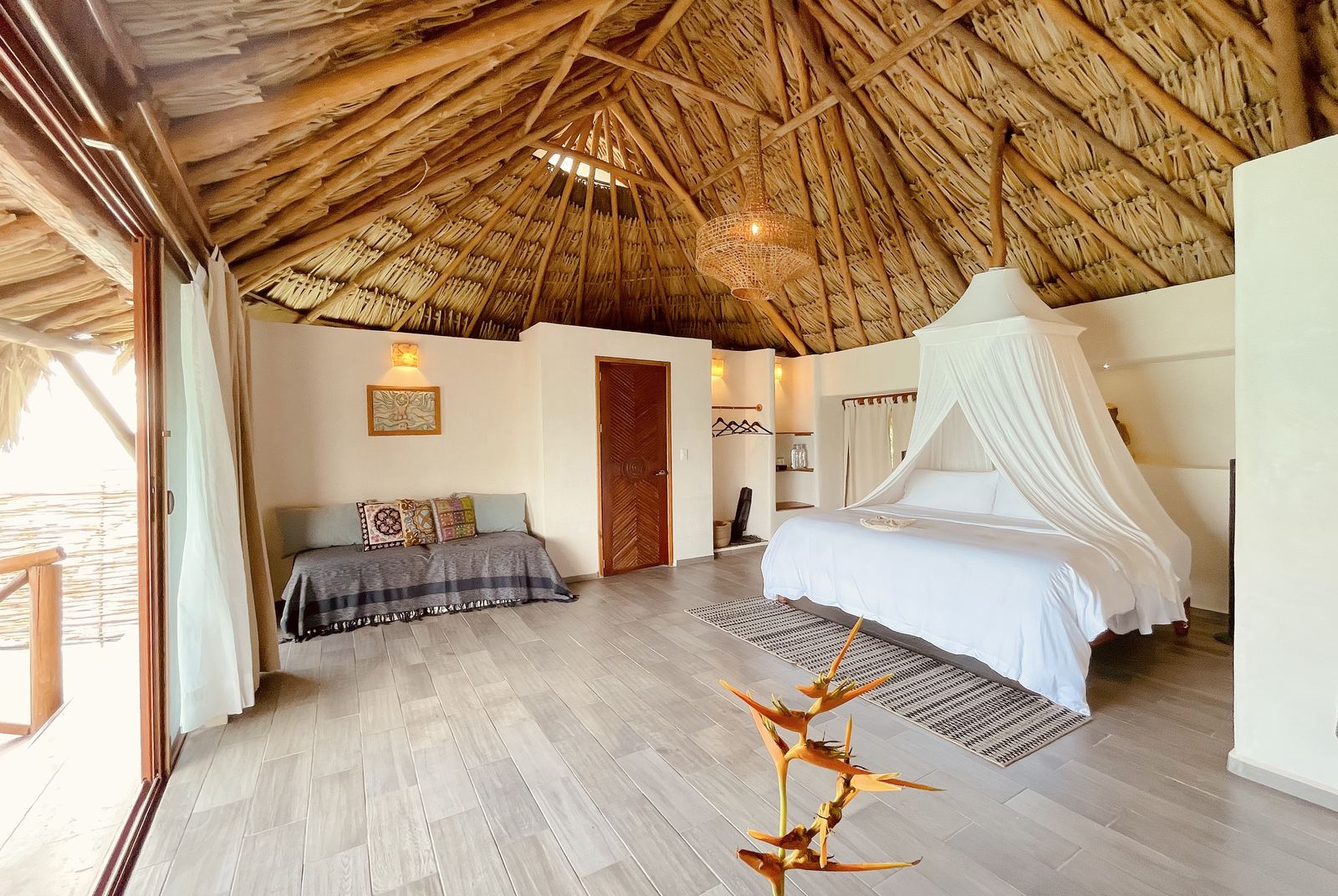 Habitación con techo de palma y mosquitero blanco